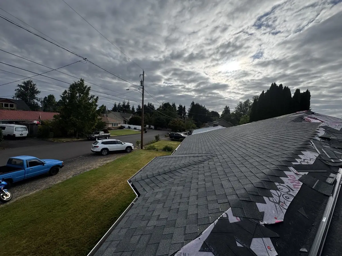 Roof replacement in progress under morning clouds by Mistletoe Construction of Douglas County Oregon